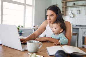 woman studying on a laptop with a baby in her lap - ways to find time to study